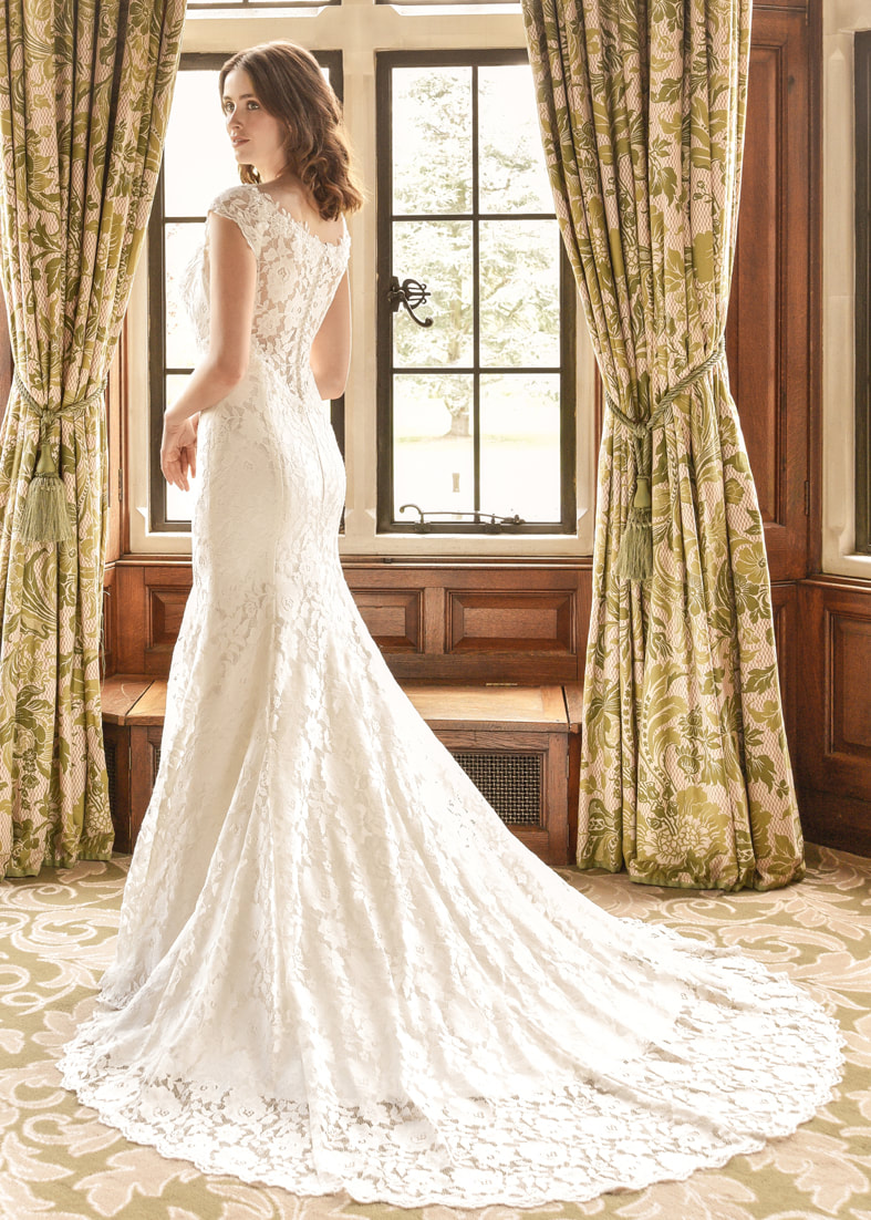 Fitted lace wedding dress with a sheer lace button through back and elegant puddle train