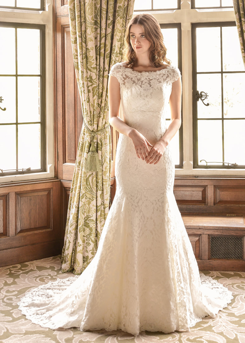 Fitted lace wedding dress with a sheer off the shoulder neckline