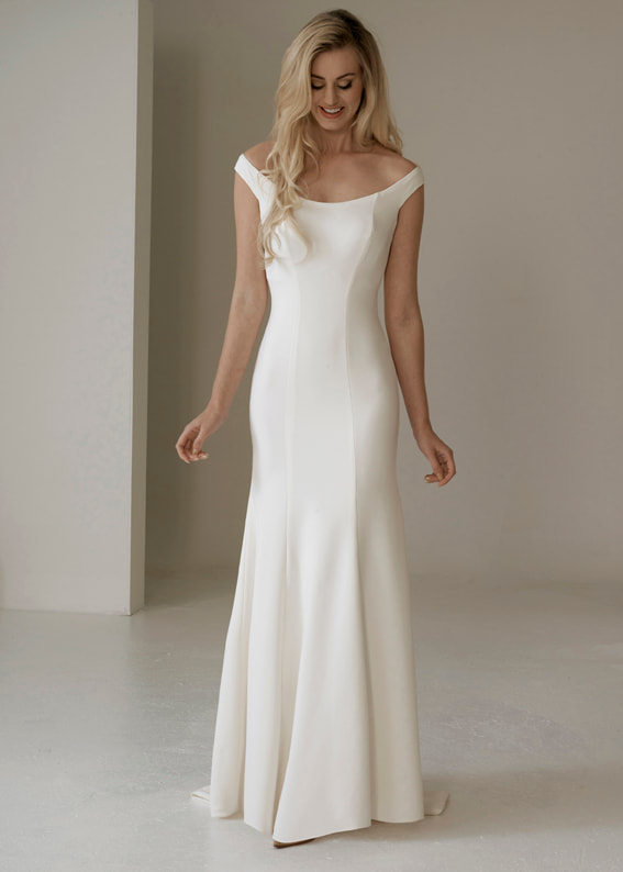 Simple fitted wedding dress with a modern off the shoulder neckline