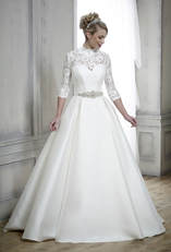 ballgown wedding dress worn with a high necked lace bridal shrug with sleeves and a beaded belt