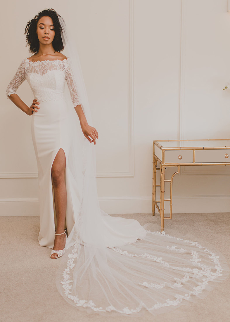 Beautiful sheer fit & flare bridal overskirt in embroidered sequin tulle. Shown worn over a strapless fitted gown with thigh split