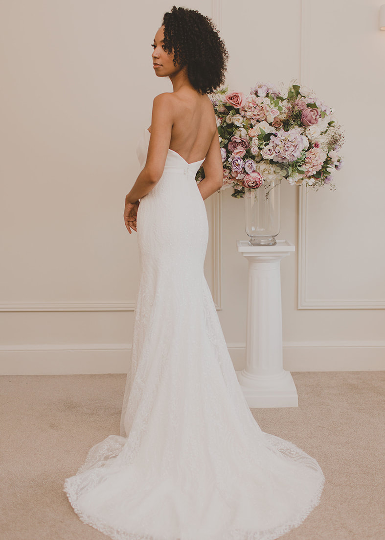 Close back shot of the Bacall fit & flare embroidered lace over skirt. Shown worn with the Bacall bridal shrug and Hepburn strapless wedding dress