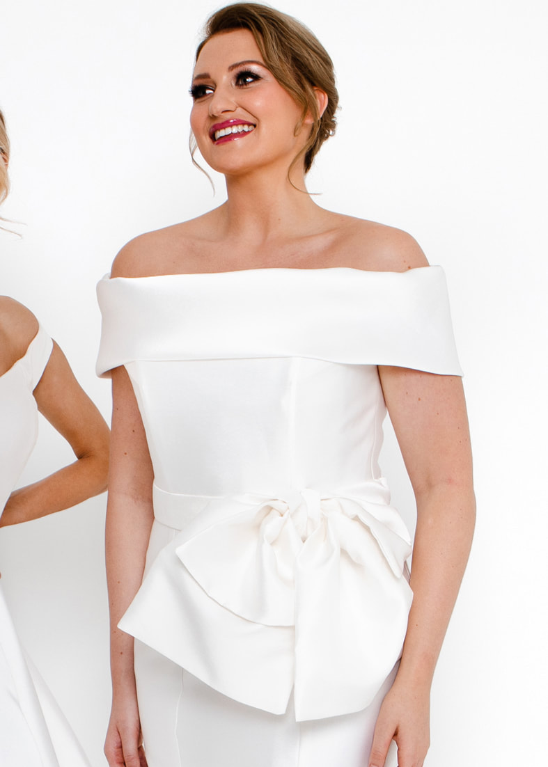 Bold bridal belt with an oversize bow detail worn with a modern wedding gown with a wide off the shoulder collar
