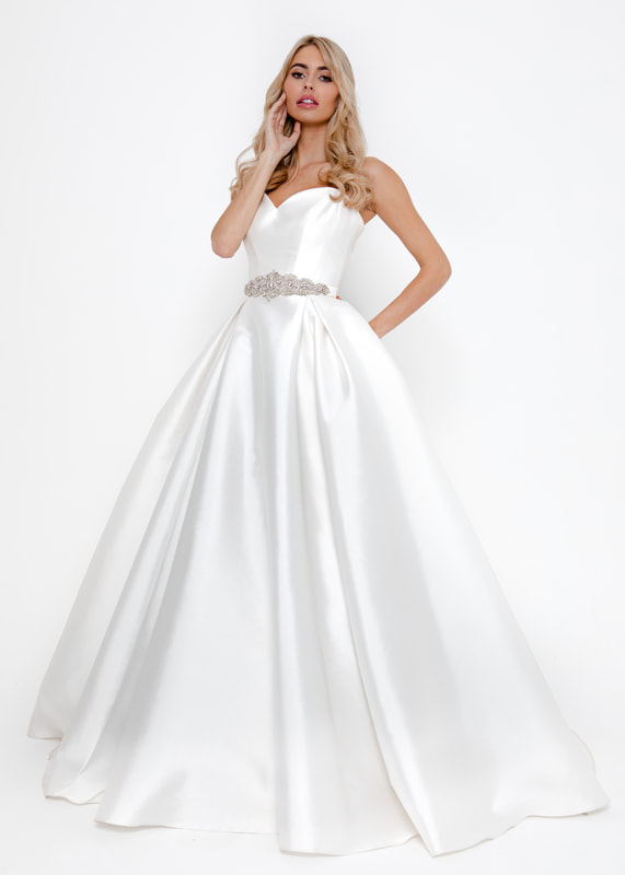 Bold an modren full skirted wedding dress with clean lines and a sweetheart neckline. Accessorised with a wide beaded belt