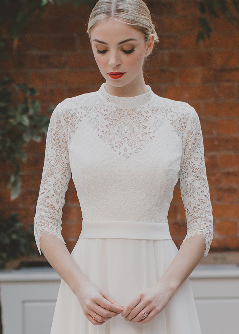 Only You  - guipure lace bridal shrug with a high neckline and 3/4 length sleeves. Worn over a simple wedding dress with spaghetti straps and a v neckline