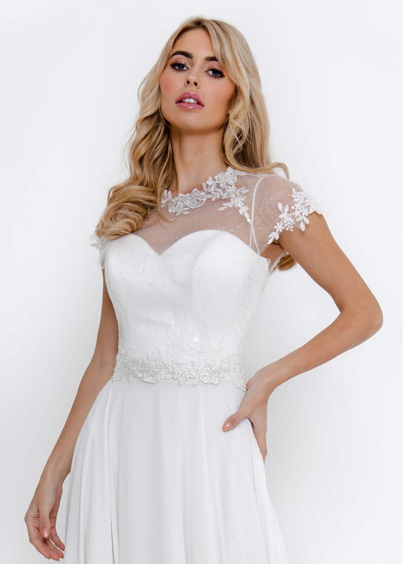 Short sleeved sheer tulle bridal shrug with applique lace details at the neckline & waist. Button fastening at the back