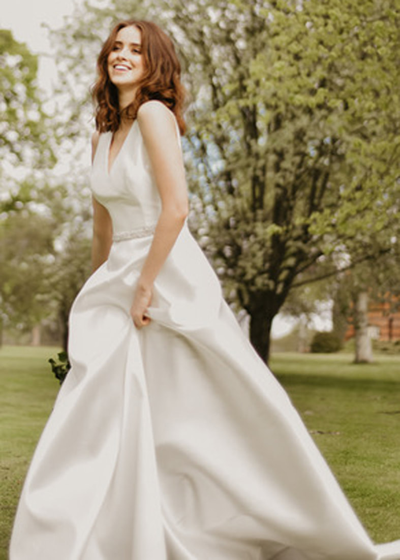 Bride wearing a simple mikado wedding dress with a low v neck and a-line skirt 
