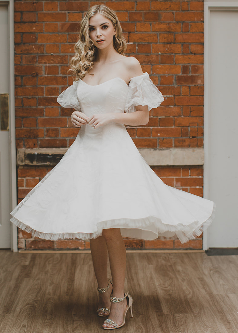 Sparkle Gown - Tea length strapless floral gillter wedding dress with a high low hemline. Wron with matching detachable glitter puff sleeves for an off shoulder look