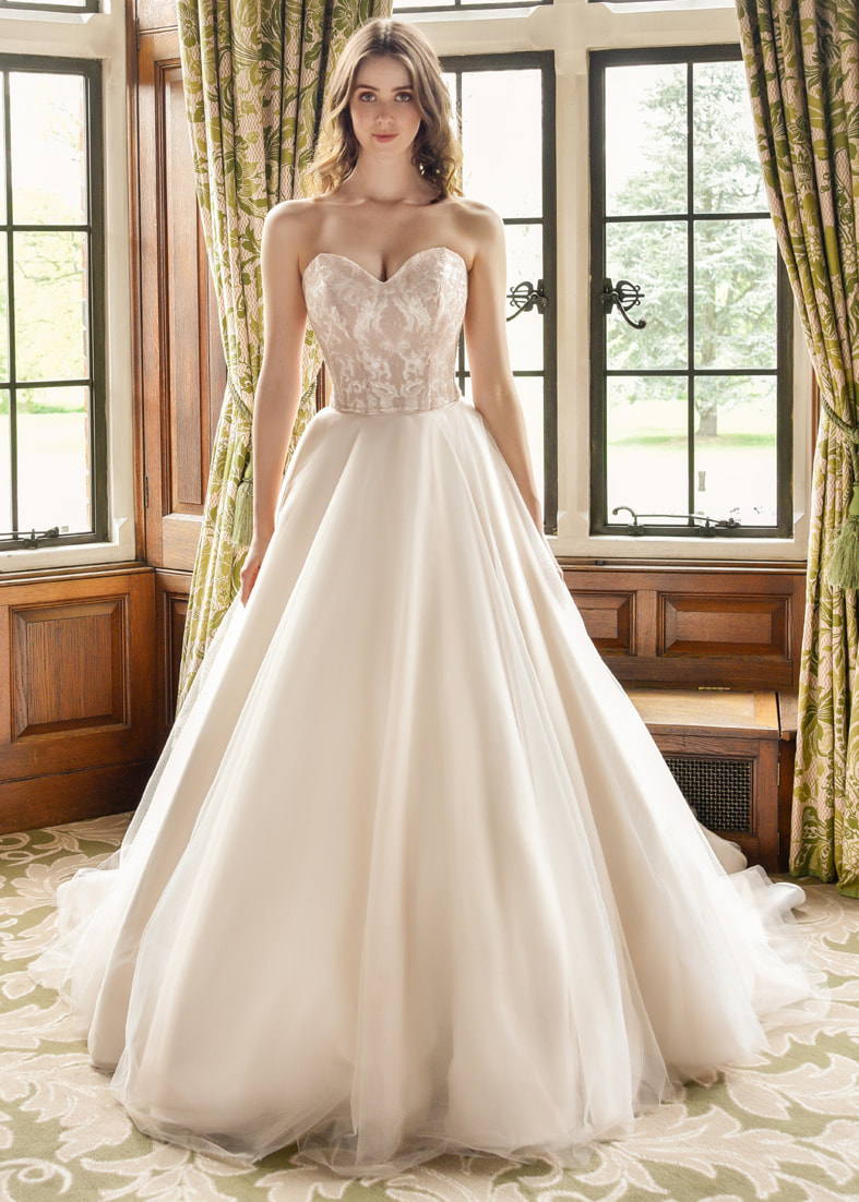 Ballgown wedding dress in shell pink with a sweetheart neckline and an ornate bodice